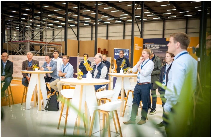 Delegates listening to a session in an exhibition hall at a Leadvent event