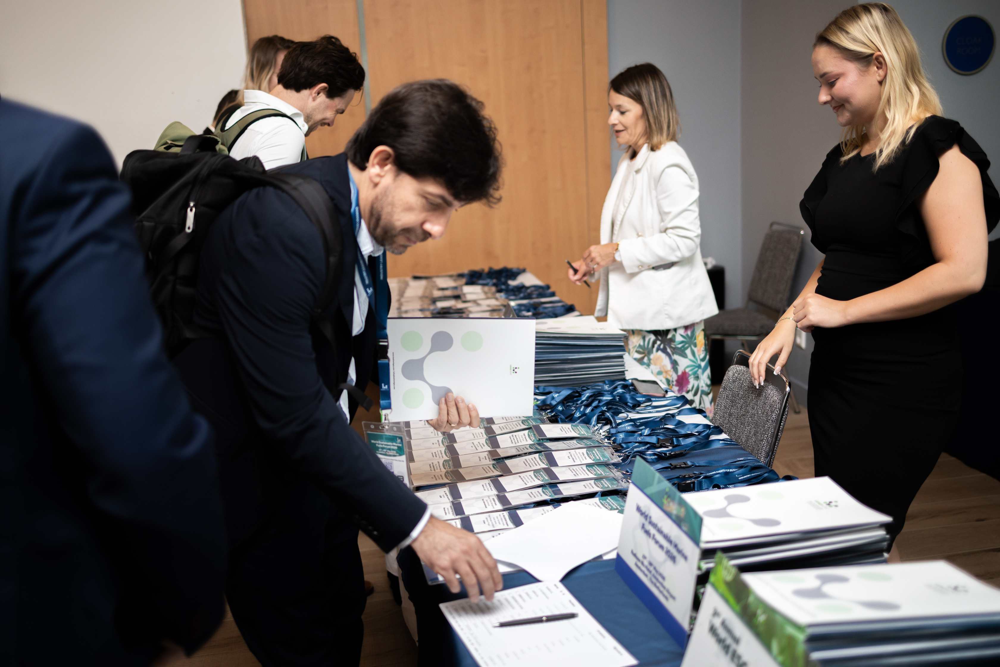 Delegates collecting badges at the registration desk of a Leadvent event